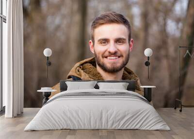 Happy man looking at camera outdoors Wall mural