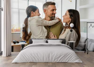 Happy masculine military man smiling and hugging his family indoors Wall mural