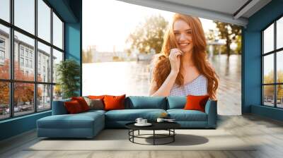 Happy pretty redhead girl with long hair looking at camera Wall mural