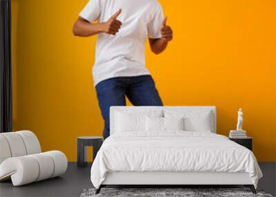 Happy young african man jumping isolated over yellow background showing thumbs up. Wall mural