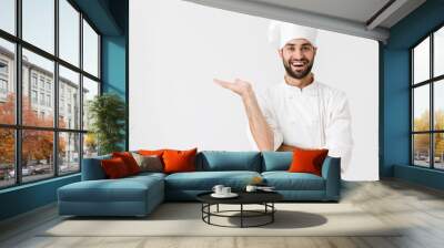 Happy young chef posing isolated over white wall background in uniform showing copyspace. Wall mural