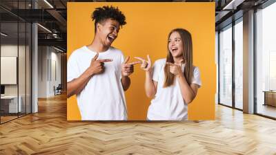 Happy young couple in basic clothing laughing Wall mural