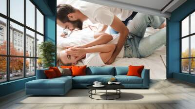 Happy young couple in love relaxing on a couch at the living room Wall mural