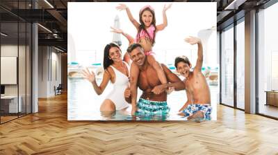 Happy young family having fun inside a swimming pool Wall mural