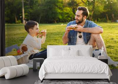 Happy young father having a picnic with his little son Wall mural