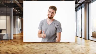 Happy young man make thumbs up gesture. Wall mural