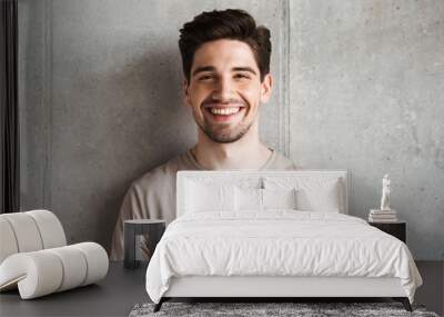 Happy young man standing over grey wall Wall mural