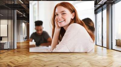 Happy young redhead lady looking camera Wall mural