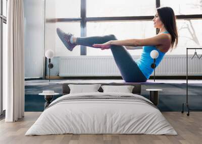 Happy young woman doing exercise on yoga mat Wall mural