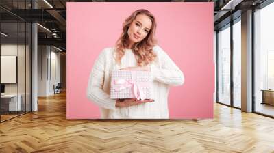 Happy young woman holding present gift box. Wall mural