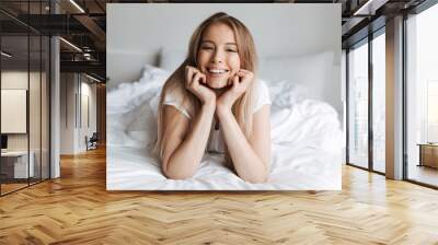 Happy young woman indoors at home looking camera Wall mural