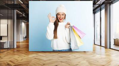 Happy young woman wearing sweater Wall mural