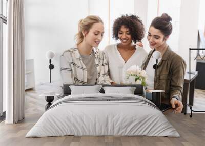 Happy young women friends having coffee break Wall mural