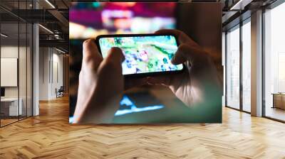 Image closeup of focused man playing video game on mobile phone Wall mural