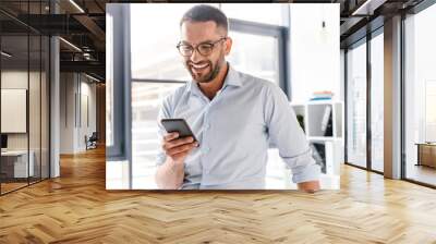 image closeup of smiling employer guy in white shirt standing in office room near big window, and us Wall mural