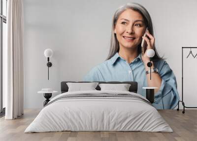 Image of adult mature woman with long white hair talking on cellphone Wall mural