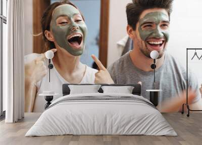 Image of beautiful couple standing in bathroom with face mask Wall mural