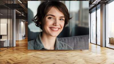 Image of brunette cute happy woman smiling and looking at camera Wall mural