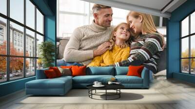 Image of caucasian happy family sitting on sofa together at home Wall mural