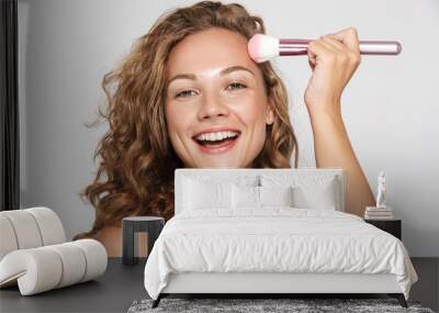 Image of funny half-naked woman smiling and using makeup brush Wall mural