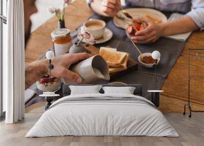 Image of modern happy couple eating together at table while having breakfast in apartment Wall mural