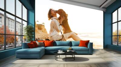 Image of pleased woman 20s hugging her dog, while sitting on sand by seaside Wall mural