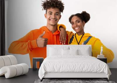 Image of pretty african american couple in colorful clothes showing thumbs up, isolated over white background Wall mural