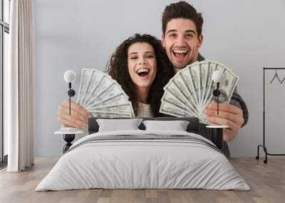 Image of rich man and woman holding fan of dollar money, isolated over gray background Wall mural