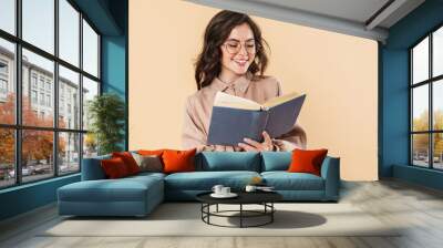 Image of smiling caucasian woman in eyeglasses reading book Wall mural