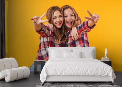 Image of two young beautiful girls smiling and gesturing peace sign Wall mural