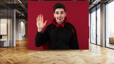 Image of vampire man with fangs in black halloween costume gesturing Wall mural