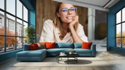 Image of woman smiling and looking at camera while sitting on couch Wall mural