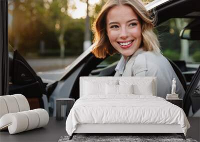 Image of young beautiful businesslike woman sitting in luxury car Wall mural