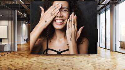 Image of young cheerful woman smiling and covering her face Wall mural