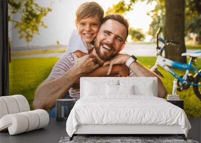 Laughing father and his son having fun together Wall mural