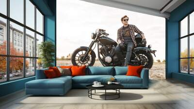 Man biker on bike outdoors at the desert field. Wall mural