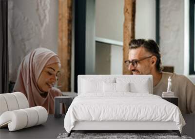 Multiracial woman and man working together in workshop Wall mural