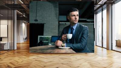 Pensive businessman drinking coffee in cafe Wall mural