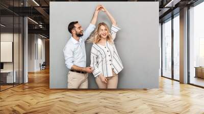 Photo closeup of joyful couple in casual clothing smiling and dancing Wall mural