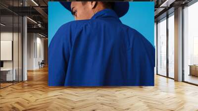 Photo from back of young african american man wearing hat and coat Wall mural