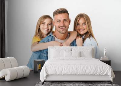 Photo of adorable caucasian family woman and man with little girl smiling and posing together at camera Wall mural