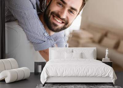 Photo of attractive brunette couple in love smiling while hugging together in apartment Wall mural