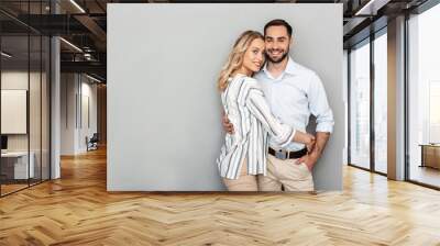 Photo of charming couple in casual clothing smiling and hugging Wall mural