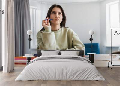 Photo of concentrated student woman thinking while doing homework Wall mural