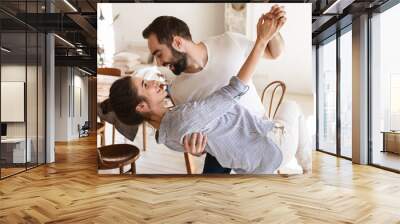 Photo of content brunette couple in love smiling while hugging together in apartment Wall mural