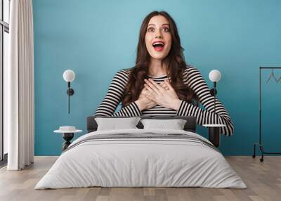 Photo of excited nice woman looking upward with hands on her chest Wall mural