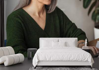 Photo of gray-haired focused businesswoman typing on laptop Wall mural