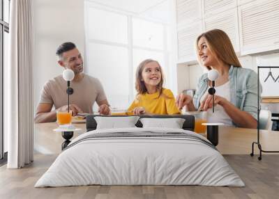 Photo of happy family smiling and talking while having breakfast Wall mural