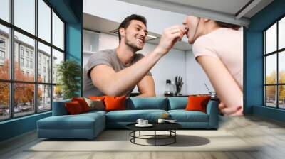 Photo of loving couple man and woman sitting at table in flat, and having breakfast together Wall mural