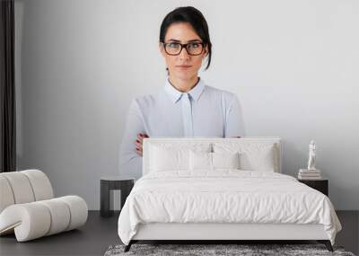 Photo of pretty businesswoman wearing eyeglasses standing in the office, isolated over white background Wall mural